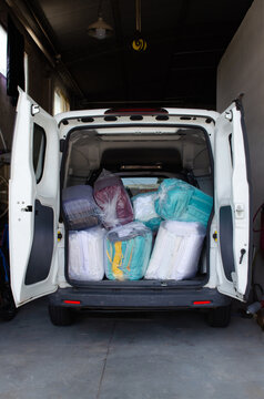 Utility vehicle loaded with clean clothes bags for delivery.