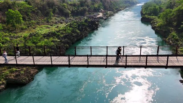 Harmony of Nature and Youth: Pupils Walking Home on a Suspension Bridge in Guangxi