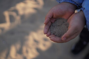 Child Hands Holding Sand at Beach