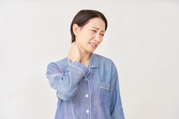 パジャマ姿の女性　寝違え　白背景