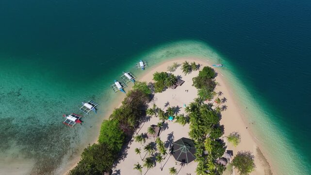 Aerial view of Palawan top travel destination in the Philippines  Cowrie Island, drone above vibrant turquoise waters and white sandy shore with fisherman boat 
