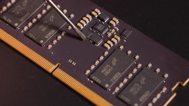 Macro Shot of Metal Tool Inspecting Components on Computer RAM Module