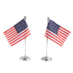 Two small American flags on silver stands.