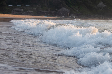 Small wave breaking on the beach shore.