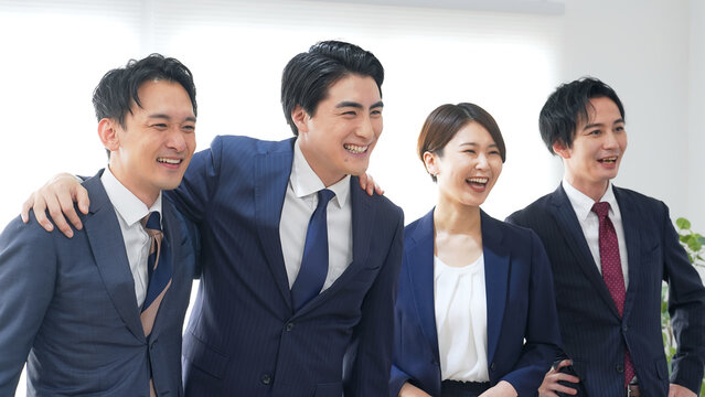オフィスで笑うビジネスパーソンのグループ
