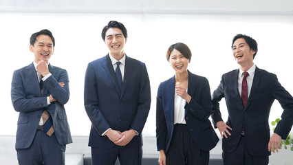 オフィスで笑うビジネスパーソンのグループ