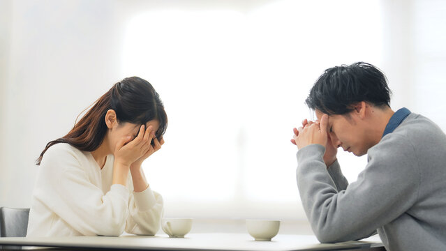 部屋で落ち込む男女カップル