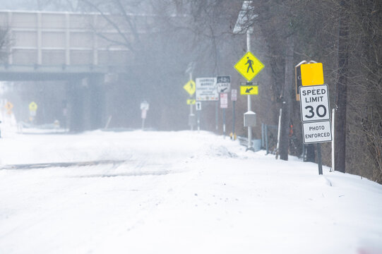 Snow and sleet fall during the January 2026 snow storm in the DMV area. Streets and sidewalks buried under a blanket of snow.