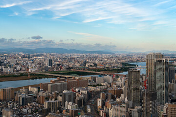 View of the Yodogawa Ward of the city and the Yodo River from the observation deck on the roof of the Umeda Sky Building skyscraper on a sunny evening, Osaka, Japan