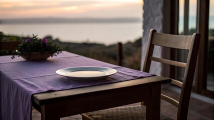 Obraz premium Minimal table with a plate on a terrace overlooking the sea at sunset. Calm lifestyle scene for banners, advertising, travel websites, restaurants, hotels and atmospheric editorial design.