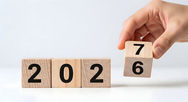 Hand flipping wooden cubes for transition from year 2026 to 2027, New Year planning and future concept