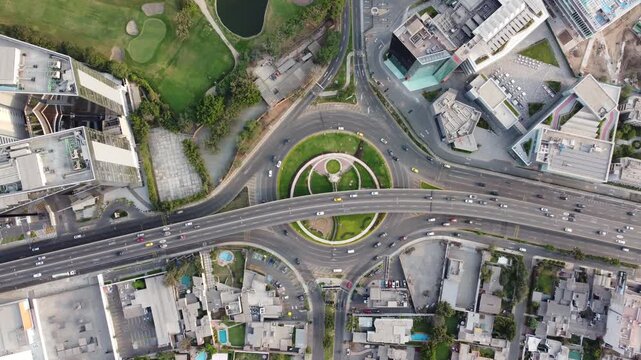 aerial roundabout intersection with traffic green central island, multilane highway cutting through