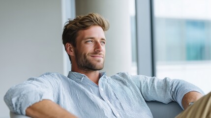Obraz premium Relaxed professional man sitting comfortably and looking away after work.