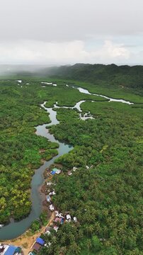 Aerial viewpoint at the river and the housing across the river at Mataob Maasin, Siargao Islands, Philippines