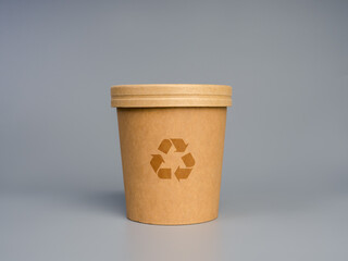 Eco-friendly paper cup with recycling symbol on gray background, representing sustainability, biodegradable packaging, environmental awareness, and zero-waste lifestyle in modern consumer culture.