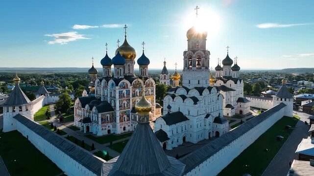 Aerial view ancient monastery with ornate domes, white walls, and a bright, sunny sky