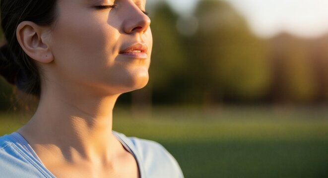 Serene woman enjoying peaceful moment in nature with closed eyes