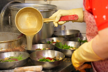 전통시장 맛집 주방에서 커다란 양은 국자로 진하게 우려낸 육수를 칼국수 그릇에 담아내는 정겨운 모습