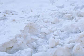 A high-contrast view of rugged winter snow background, showcasing the heavy, uneven texture of a deep freeze. © Ink N Propeller