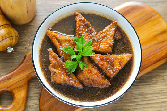 A bowl of Braised Tofu (Tahu Semur). These tender tofu triangles are slow-braised in a fragrant, sweet soy sauce gravy, creating a perfect balance of savory and sweet.