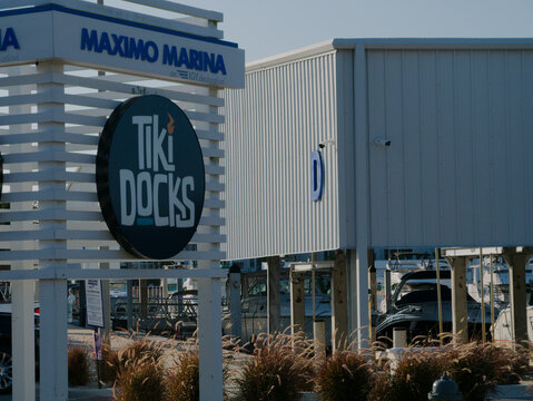 Maximo Marina Sign At IGY Destination Under Clear Sky With Palm Trees. Editorial Use Only  January 25, 2026. St. Petersburg, FL, USA. Outdoor sign rises against a bright blue sky. Near industrial buil