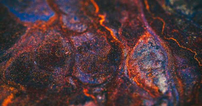 Defocused shimmering background. Ink stream. Heat magma burning in volcanic colorful texture. Orange red dye lava spill on abstract black particles.
