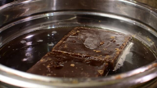 Melting panela in pot, sweet cooking process, culinary activity