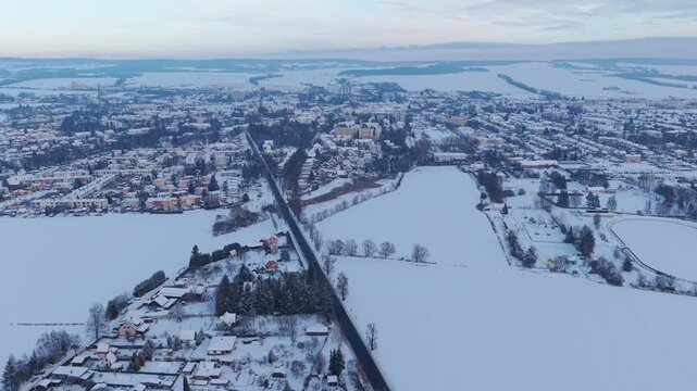 Aerial panorama of Svitavy city in winter, houses covered in snow.
Drone view of snowy urban landscape surrounded by cold atmosphere.