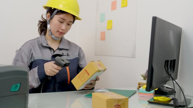 Asian female engineer handle parcel boxes by reading the barcode stickers with a barcode scanner to record the information in the computer.