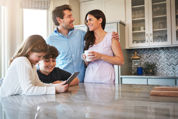 Obraz premium Talking, parents and kids in kitchen, tablet and laughing together with teaching app. Home, support or happy mother with father, subscription or website info for child development, humor or elearning