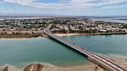 Obraz premium Port Augusta City, South Australia – aerial drone view of residential houses, urban estates, bridges, river, traffic, Spencer Gulf and regional city landscape