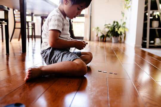 Young boy counting money on the floor