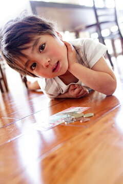 Young boy lying on the floor counting money