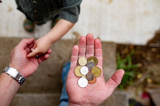 Close up of a hand holding several coins