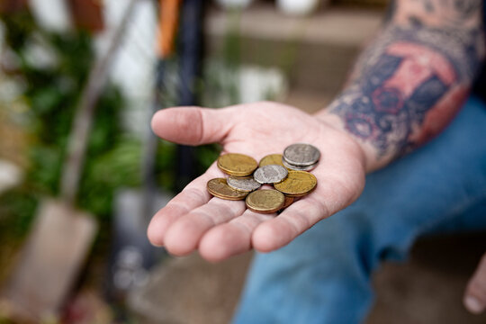 Close up of a hand holding several coins