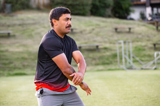 Samoan man posing haka dance move in a green field