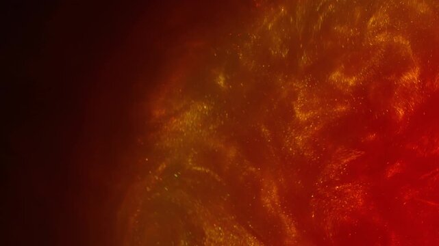 Wet shimmering. Lava art flow. Red orange sparkling particles spreading on black background. Color dust ink abstract blend blur heat water.