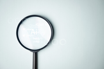 Artificial intelligence concept with glowing AI brain hologram under magnifying glass. Represents...