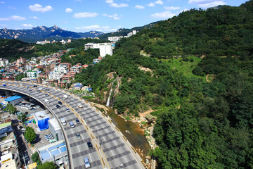 Fototapeta premium Aerial view of Bukhansan Mountain and Seoul city skyline under clear blue sky