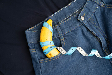 Banana with measuring tape on jean trousers, penis health.