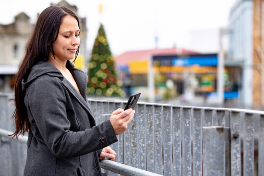 Maori woman using her phone in an urban street