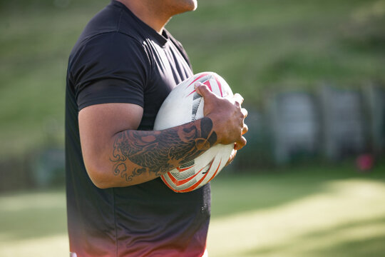 Man holding ruby ball in a sports field