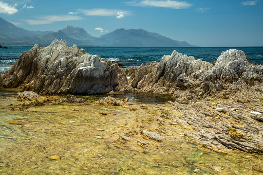 Geological limestone coastal formations with the Kaikoura Ranges in background