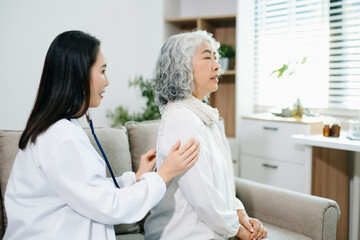 Obraz premium Healthcare professional using stethoscope to examine elderly woman at home. Senior medical checkup, heart health, home care, diagnosis, prevention