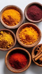 Flatlay wooden bowls with colorful spices turmeric paprika cinnamon on white background. Ethnic kitchen ingredients, sustainable food portrait, copy space