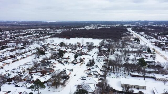 Aerial drone view of Fort Worth suburban neighborhoods & parks in January 2026 covered in snow & sleet