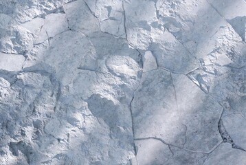 Tactile rough concrete stone texture with cracks and subtle imperfections on seamless background. Urban minimal aesthetic, calming 2026 All the Feels trend.