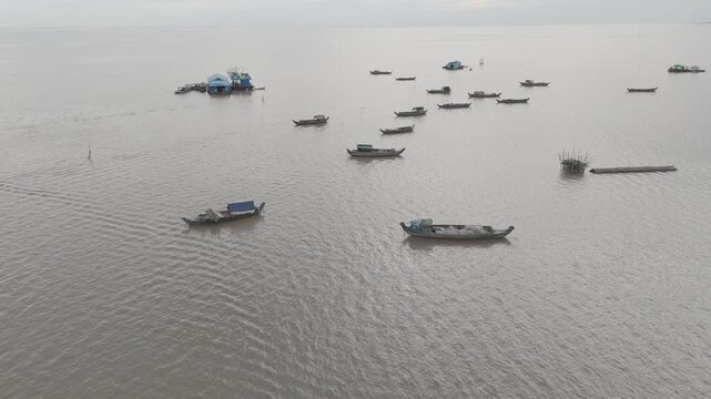 Vues drone 4K de Kampong Phluk, village sur pilotis au Cambodge, le long du M&eacute;kong : maisons flottantes, barques et reflets dor&eacute;s. Id&eacute;al pour projets voyage, culture, nature et Asie authentique.