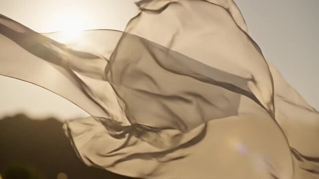 Flowing fabric waving gently in the breeze against a bright sky from a low angle view