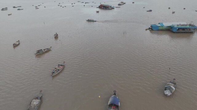 Vues drone 4K de Kampong Phluk, village sur pilotis au Cambodge, le long du M&eacute;kong : maisons flottantes, barques et reflets dor&eacute;s. Id&eacute;al pour projets voyage, culture, nature et Asie authentique.